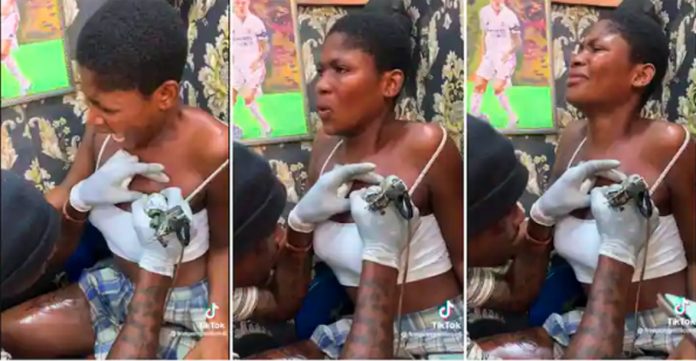 Lady screams in pain while being given tattoo on her chest (Video)