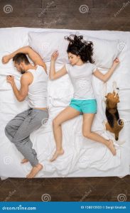 Young Couple Relaxation on the Bed Top View with a Dog Sleeping NRUSVCYdeHt4JM